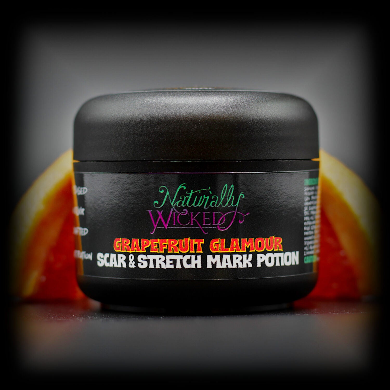 Naturally Wicked Grapefruit Glamour Scar & Stretch Mark Potion For Repairing Body Marks, Amongst A Vibrant Red Slice Of Grapefruit