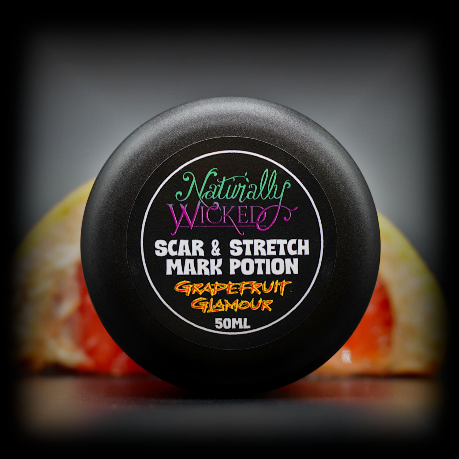 Naturally Wicked Grapefruit Glamour Scar & Stretch Mark Potion for Reducing & Preventing Body Marks, Amongst Bright Red Grapefruit Slices