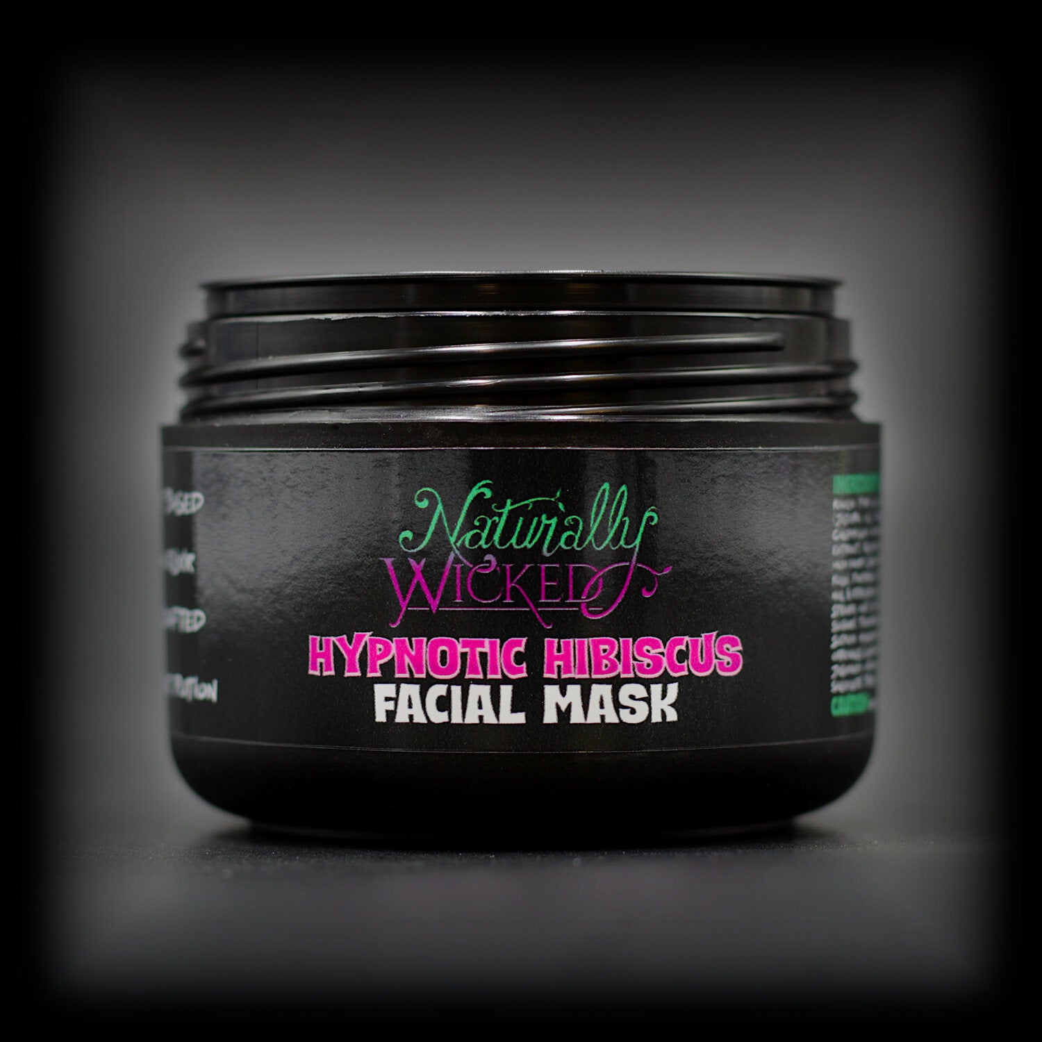 Naturally Wicked Hypnotic Hibiscus Facial Mask in chic black container with lid off and vibrant label.