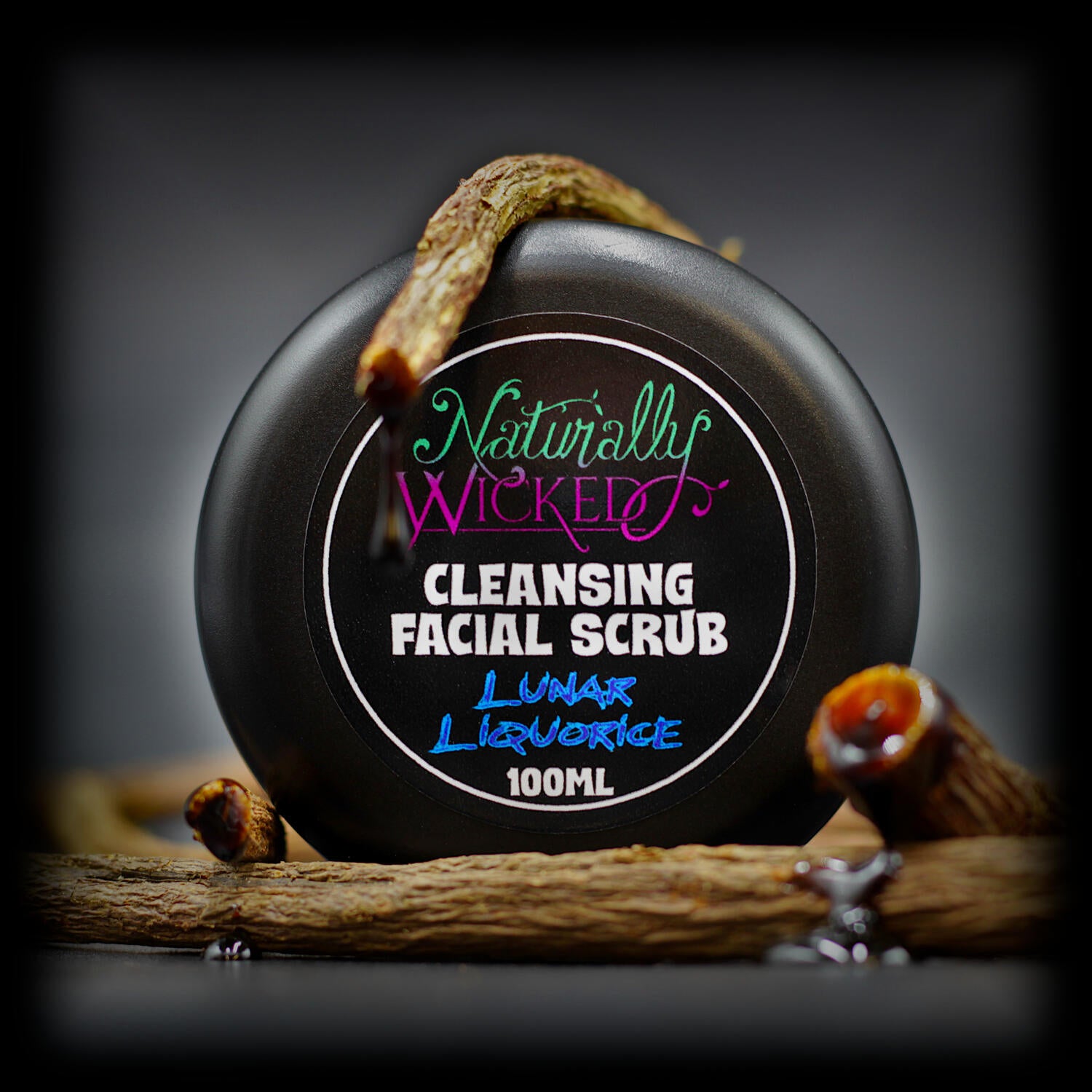 Naturally Wicked Cleansing Facial Scrub with Lunar Liquorice, in black tub styled with dripping liquorice roots