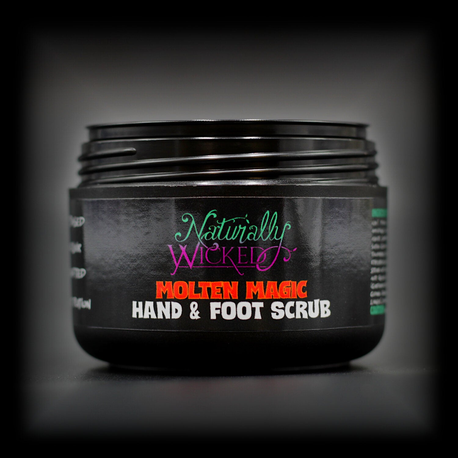 Naturally Wicked Molten Magic Hand & Foot Scrub in black tub with lid off, displaying bold red label.