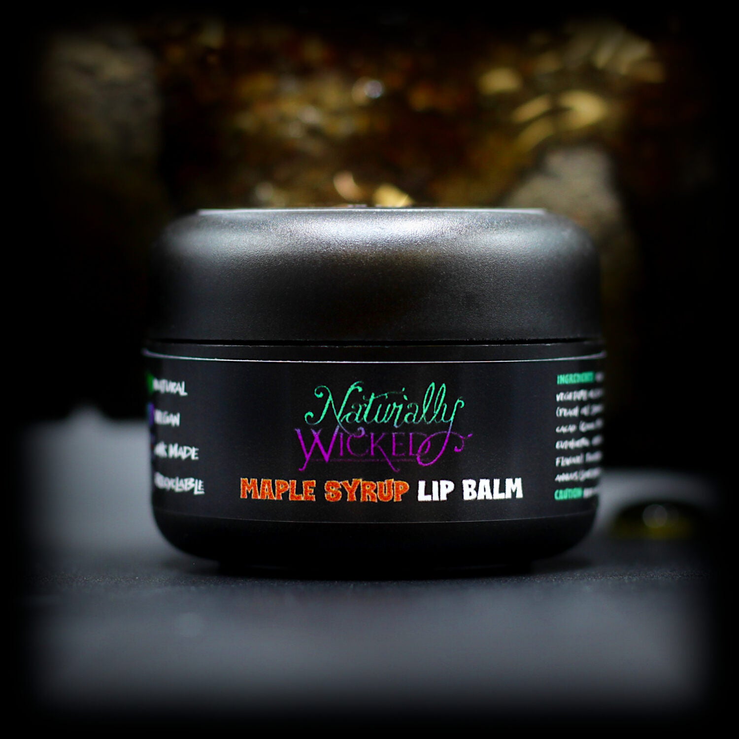 Naturally Wicked Maple Syrup Lip Balm Beside Maple Log Bleeding Dark Maple Sap