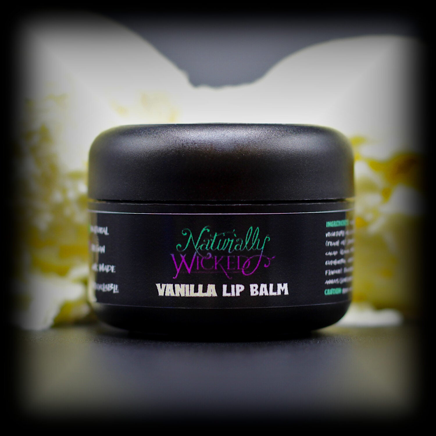 Naturally Wicked Vanilla Lip Balm In Front Of Vanilla Ice Cream Scoops