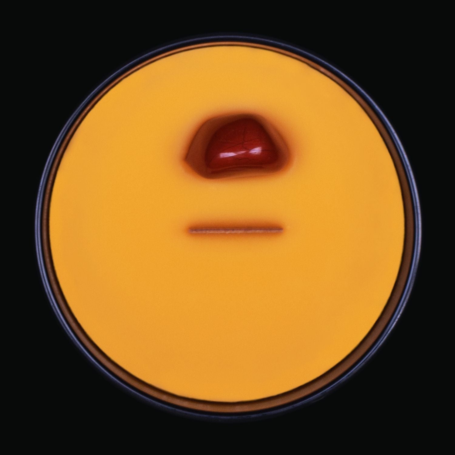 Naturally Wicked Spellbinding Friendship Crystal Candle View From Above Shows Orange Smooth Plant-based Wax, Featuring A Wooden Wick And Red Jasper Spell Crystal. All Situated Within A Black Gloss Glass Container. A truly Unique Gift