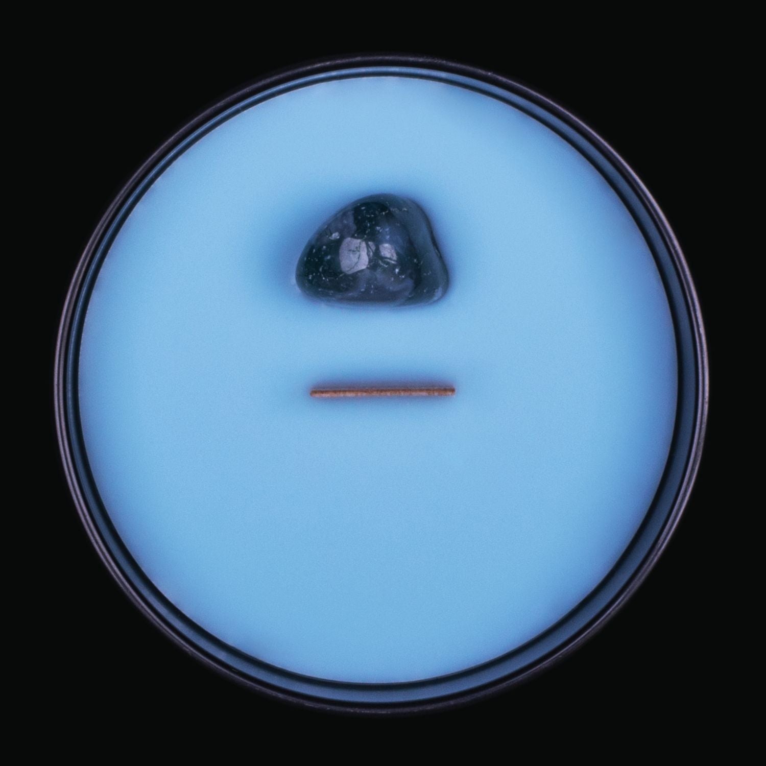 Naturally Wicked Spellbinding Health Crystal Candle View From Above Shows Blue Smooth Plant-based Wax, Featuring A Wooden Wick And Teal Banded Agate Spell Crystal. All Situated Within A Black Gloss Glass Container. This Spell Candle is a Unique Gift For Someone You Love