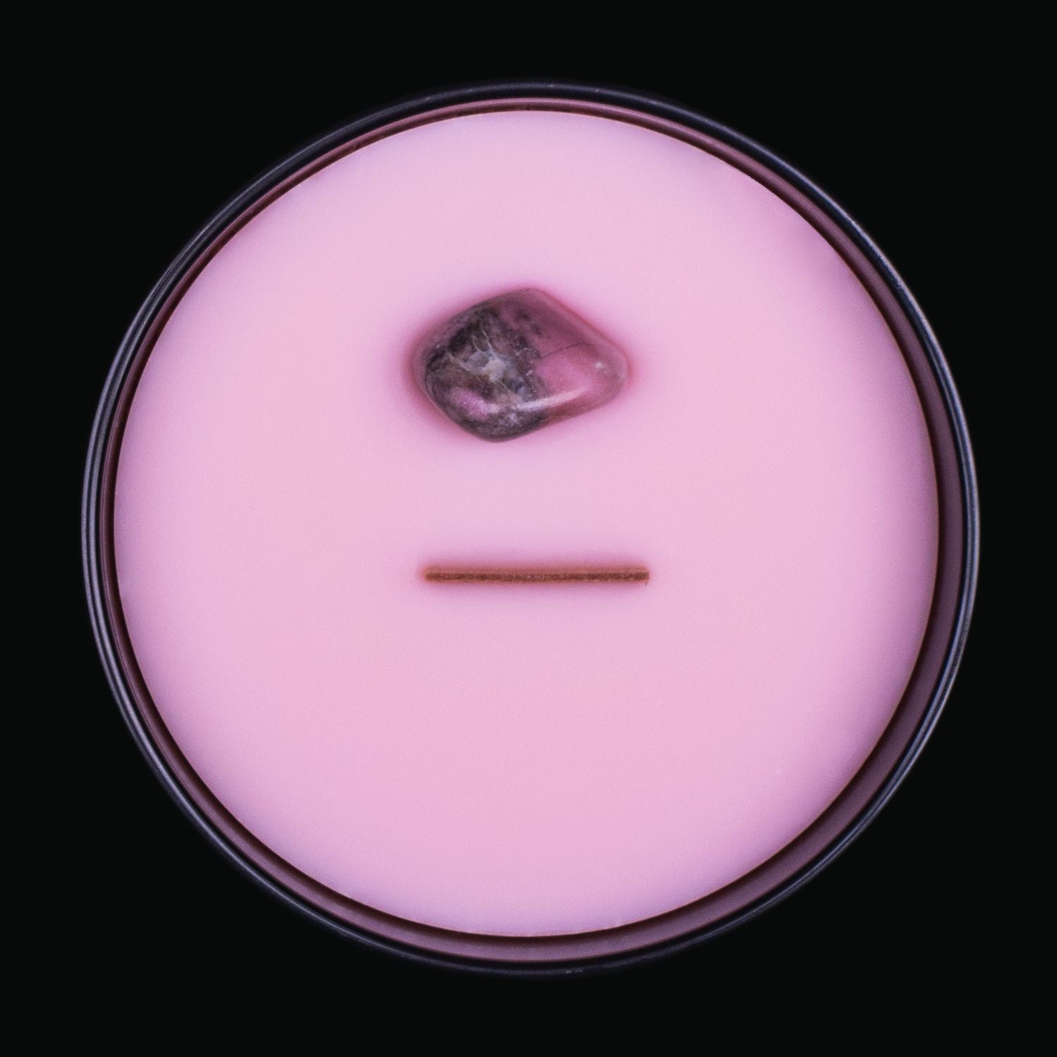 Naturally Wicked Spellbinding Sex Crystal Candle View From Above Shows Pink Smooth Plant-based Wax, Featuring A Wooden Wick And Rhodonite Spell Crystal. All Situated Within A Black Gloss Glass Container. The Perfect Gift For A Divine Temptress