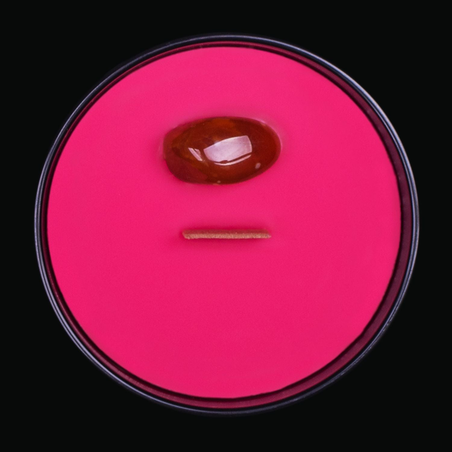 Naturally Wicked Spellbinding Vengeance Crystal Candle View From Above Shows Rich Red Smooth Plant-based Wax, Featuring A Wooden Wick And Carnelian Spell Crystal. All Situated Within A Black Gloss Glass Container. A Gift For A Wicked Soul